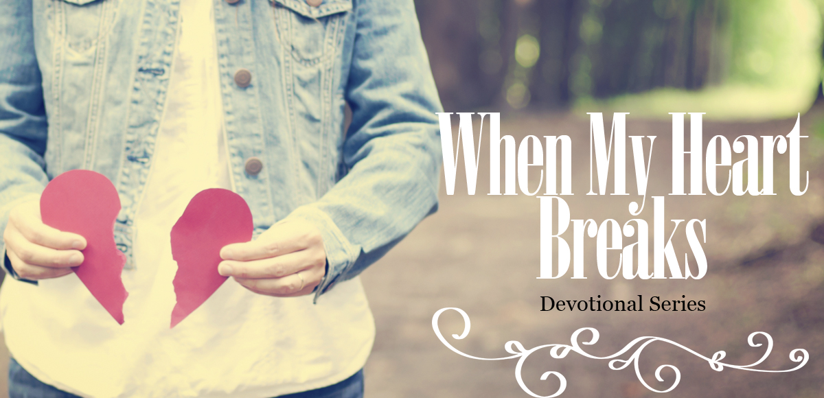 Woman standing with broken heart made of red paper